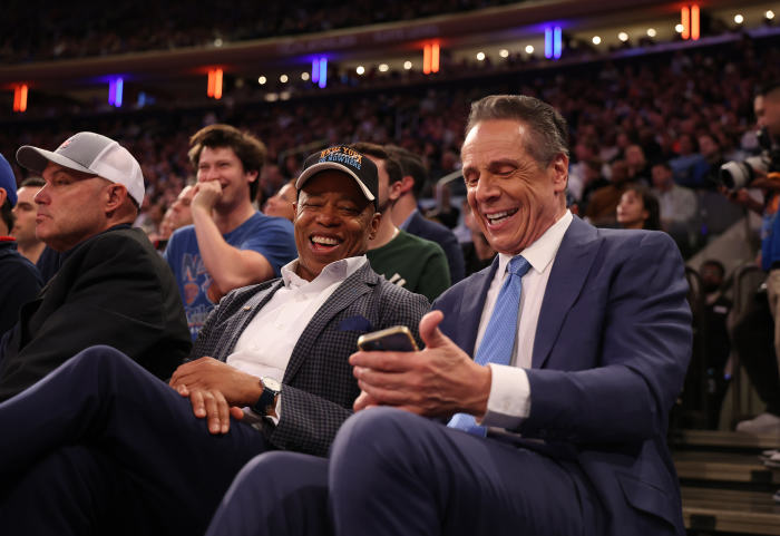 New York Mayor Eric Adams and former New York Governor Andrew Cuomo laughing while seated at a game.
