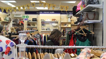 Woman browsing clothes in a Mind charity thrift shop.