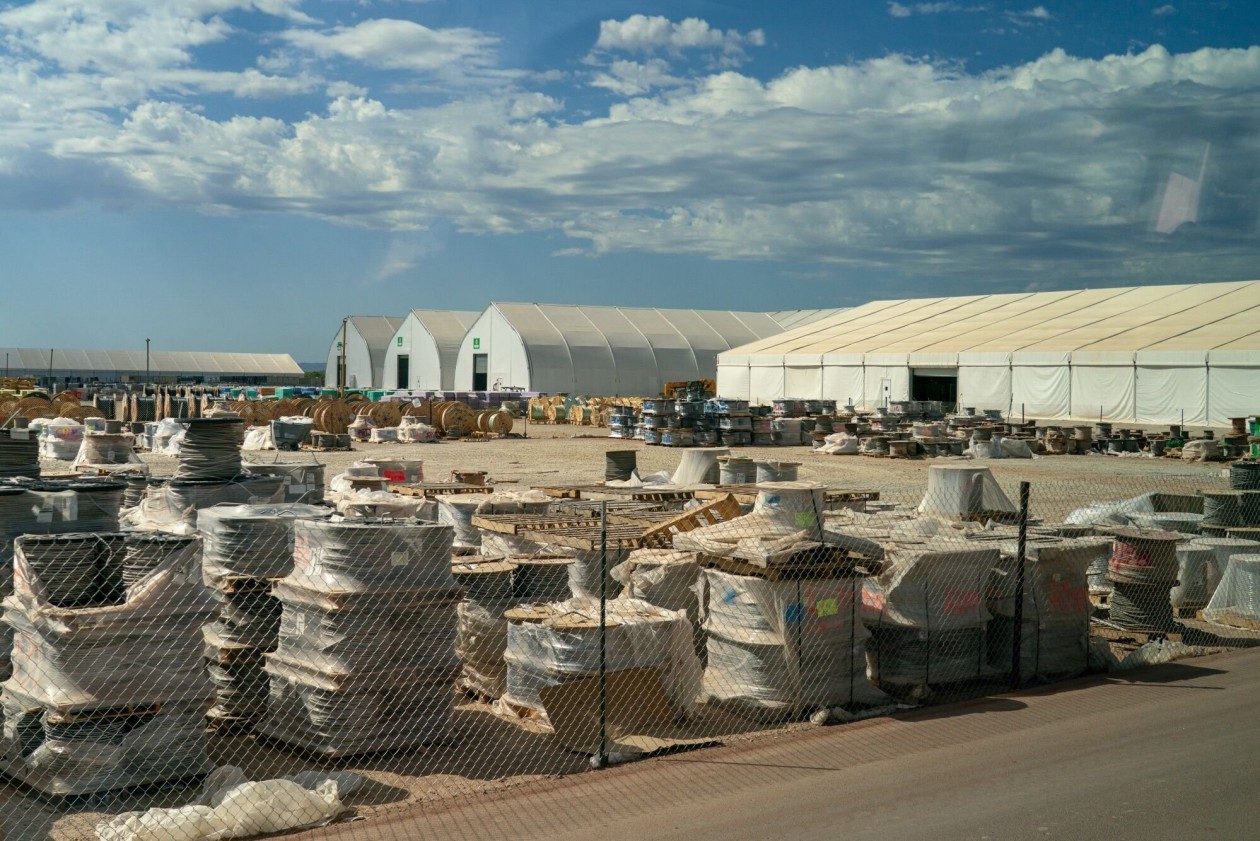 Spools of electrical wires in front of white assembly tents at the Stargate AI data center.