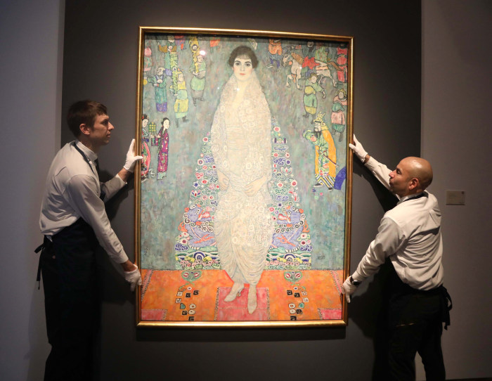 Handlers moving the painting “Portrait of Elisabeth Lederer” by Gustav Klimt.