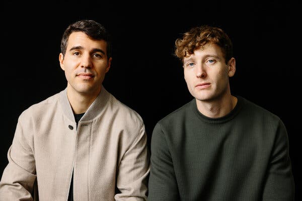Gabe Pereyra and Winston Weinberg pose next to each other in front of a black background. They are seen from the waist up.