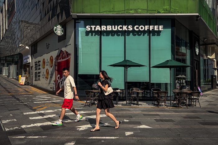 Pedestrians walk past a Starbucks Coffee store on May 20, 2025 in Chongqing, China.