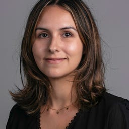 Julia Pugachevsky's face on a gray background.