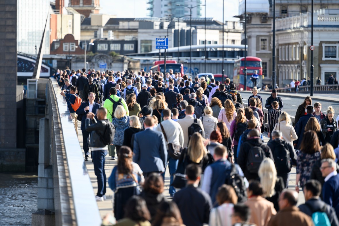 A large crowd of people commuting to work on London Bridge.