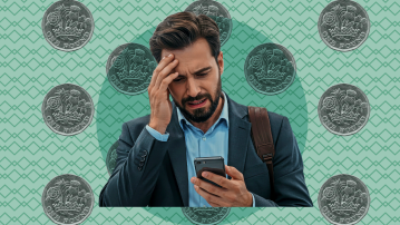A man looks stressed while holding his phone, with one pound coins in the background.