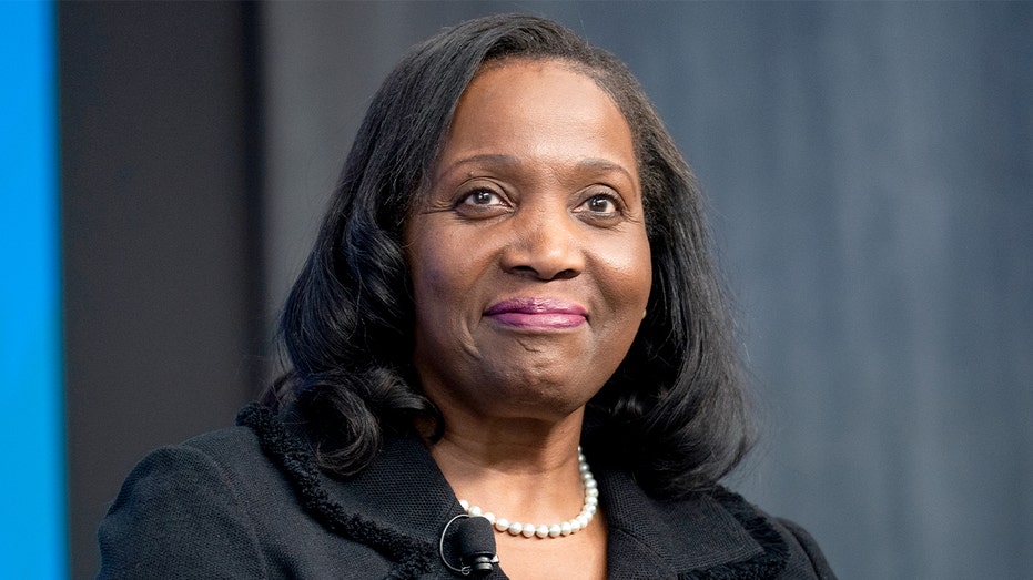 A woman speaks while seated on a stage during a policy discussion at a Washington think tank.