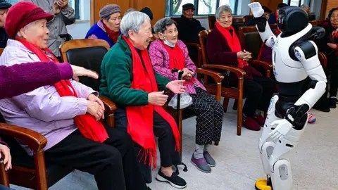 Getty Images Elderly people interact with an intelligent robot at a nursing home on January 7, 2026 in Kunshan, Jiangsu Province of China