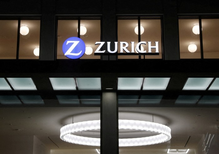 The Zurich Insurance logo on the headquarters building at night.