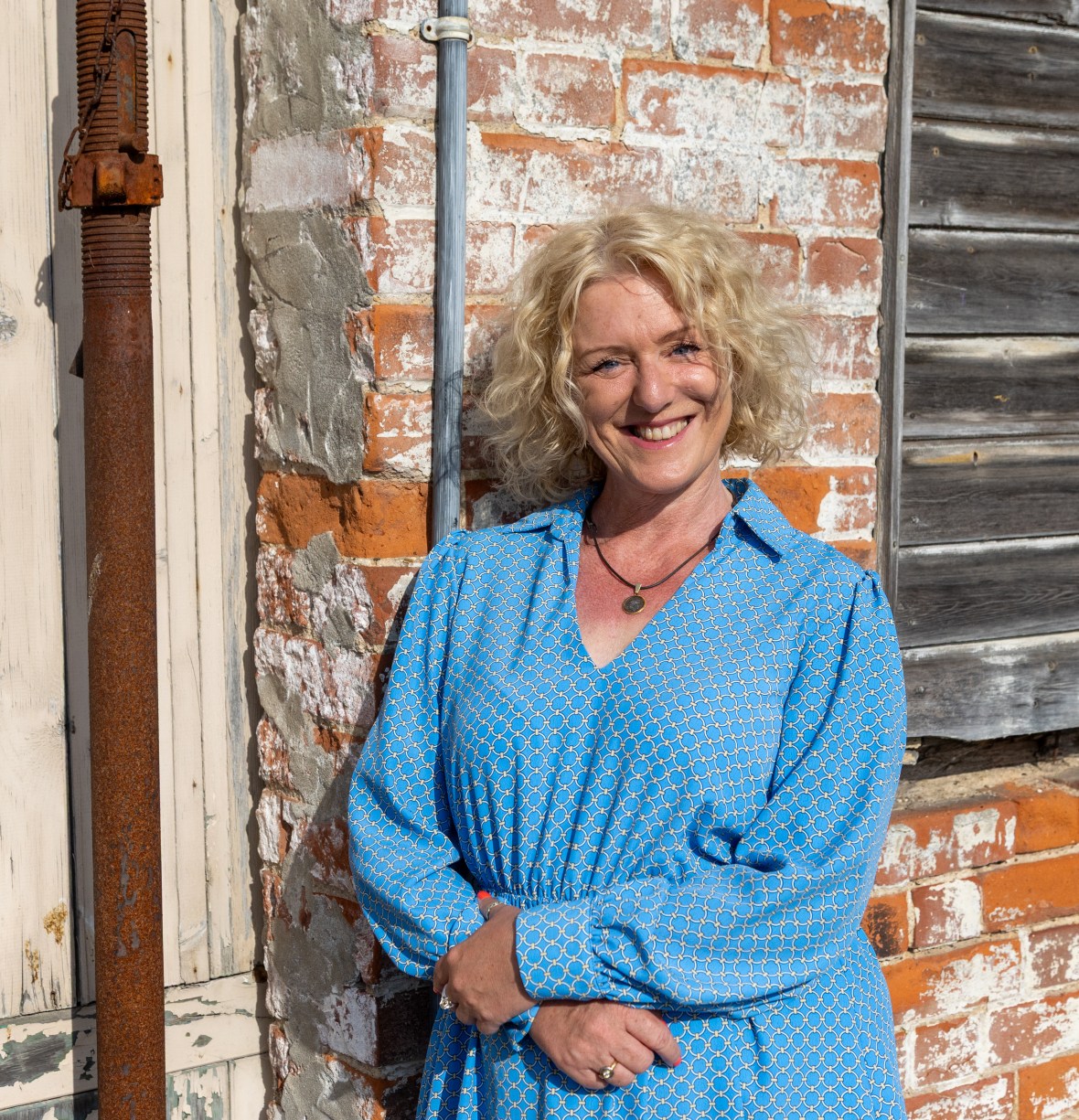 Samantha Collett, who is selling some of her properties, standing in front of a brick wall.