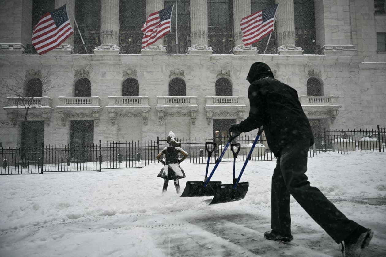 A worker shovels snow outside the New York Stock Exchange.
