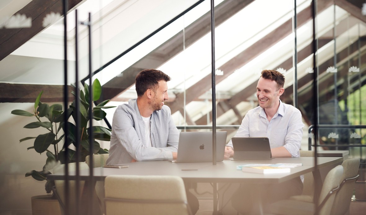 Rob Dix and Rob Bence sitting at a table with laptops, smiling.