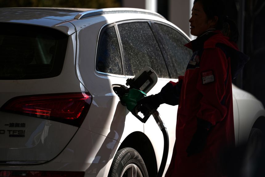 An attendant helps a motorist fill a car at the Sinopec petrol station, in Beijing, Monday, March 9, 2026.