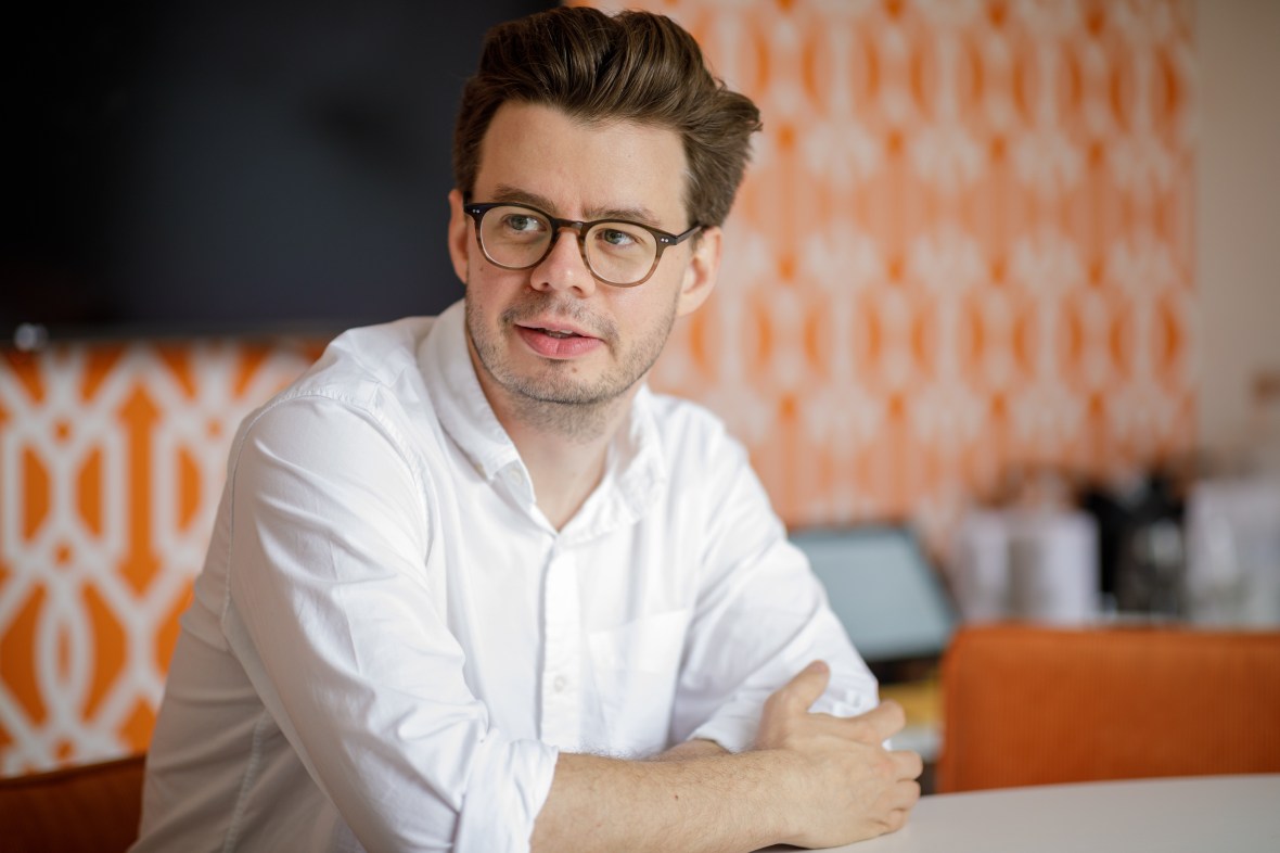 Marc Warner, Faculty AI CEO, wearing a white shirt and glasses, looking to his left.