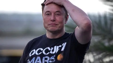 Reuters SpaceX founder Elon Musk wears a dark t-shirt with white lettering reading "Occupy Mars" next to a picture of a small red planet